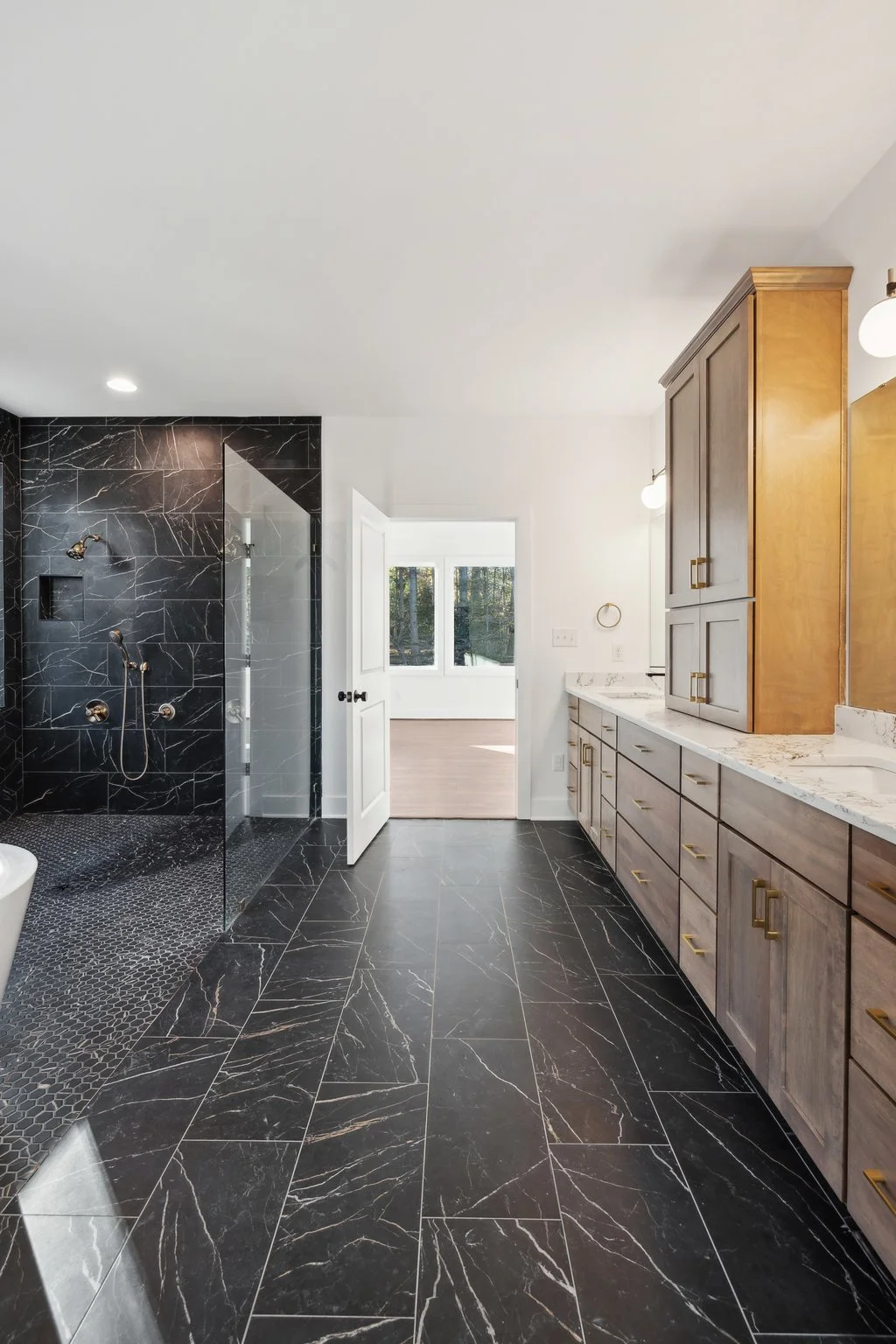 Spacious bathroom featuring black tile and a walk-in shower.