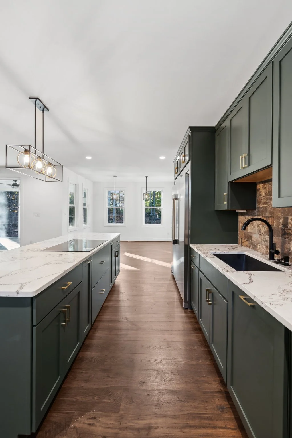 Stylish kitchen with green cabinetry and brick backsplash