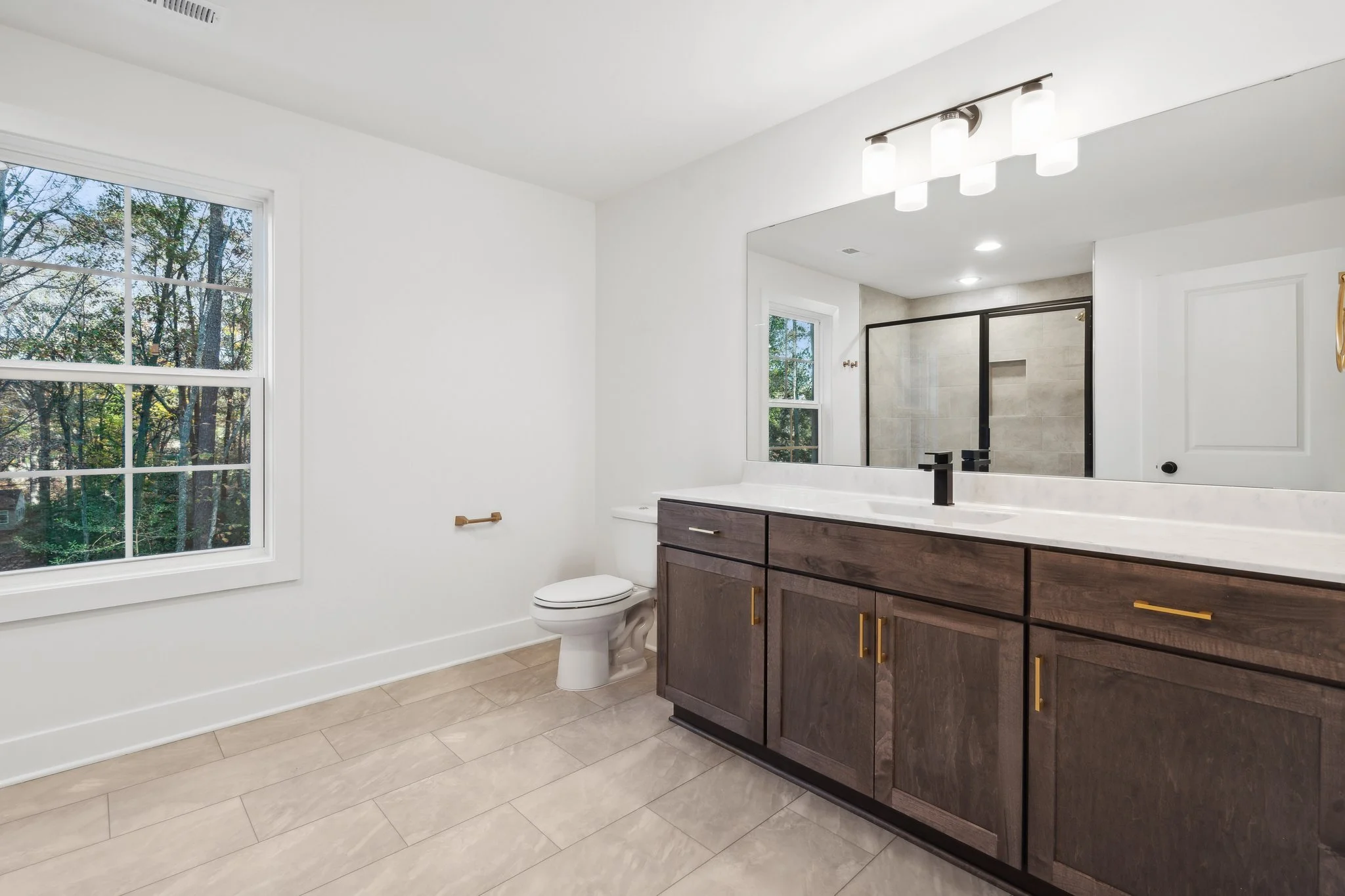 Master bathroom with dual vanities and natural light.