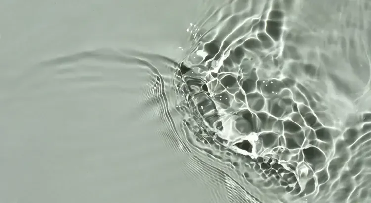 Close-up of sunlight reflecting off the surface of water, creating bright, wavy patterns.