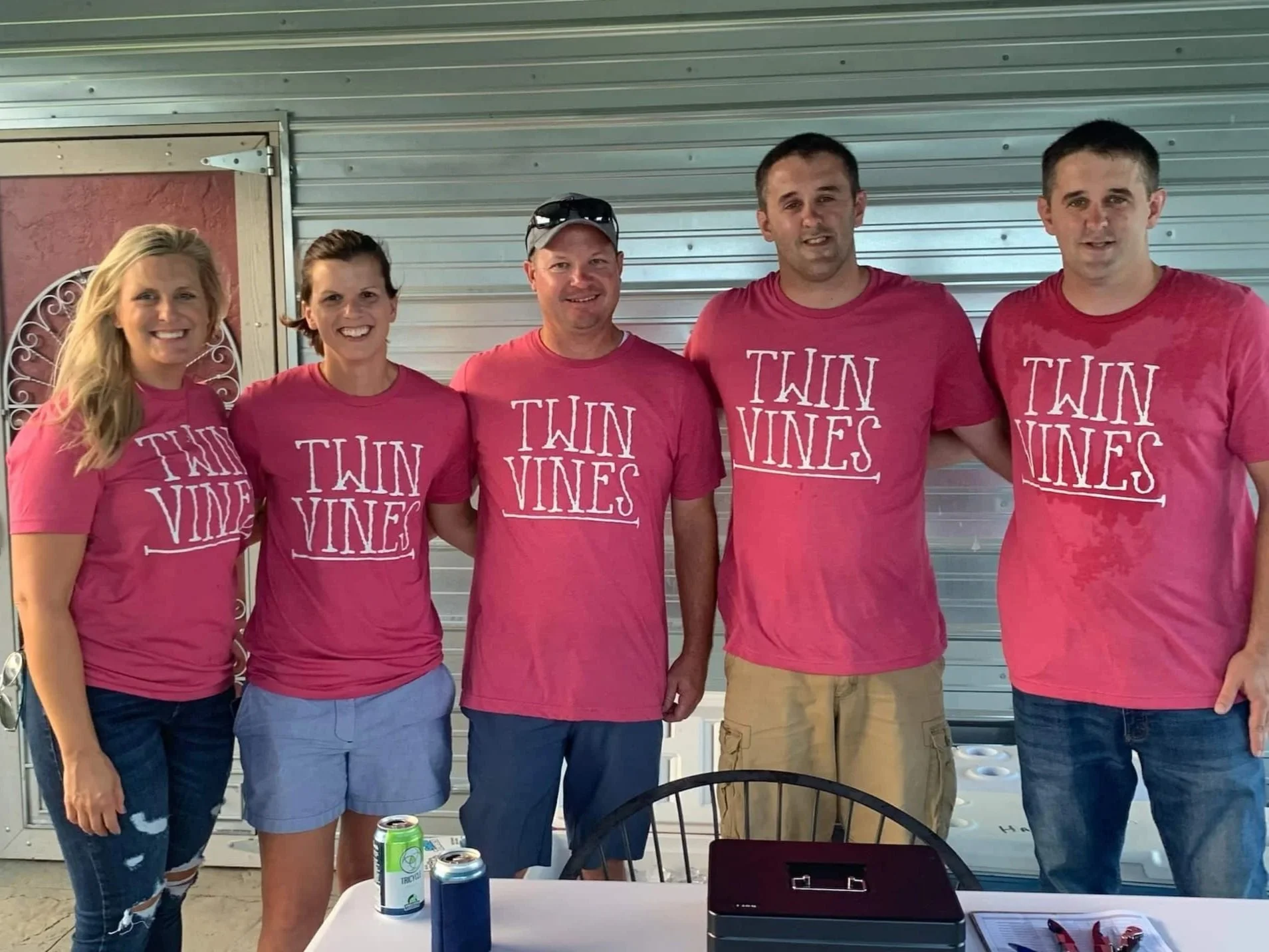 Twin Vines team photo with 5 employees wearing pink shirts with vineyard logo.