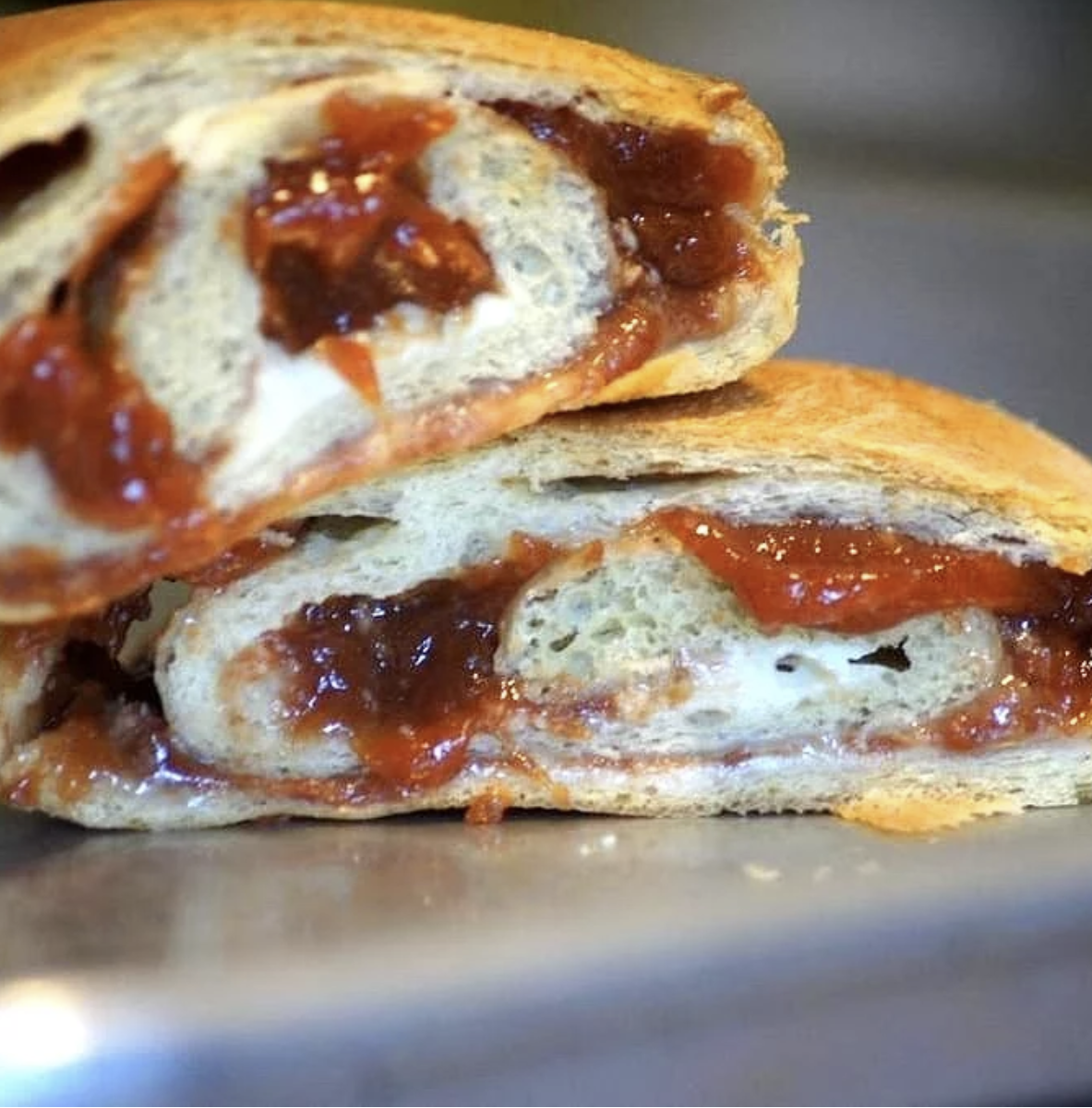 Close-up of a sandwich with tomato and melted cheese filling