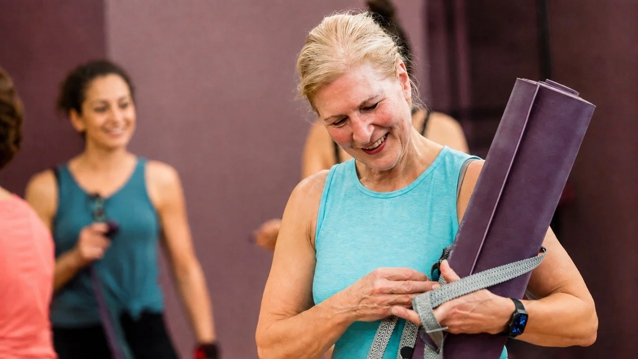 Student smiling with her yoga mat at Prana Yoga Center in Geneva, Illinois