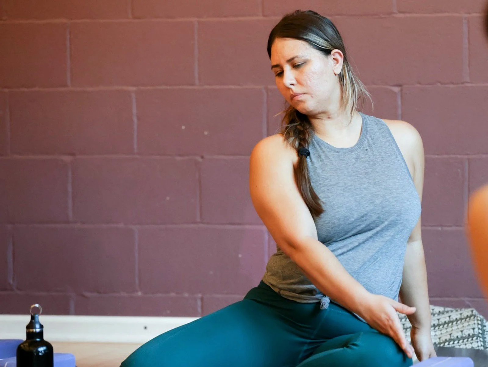 Student in a gentle seated yoga twist for summer digestive ease at Prana Yoga Center.