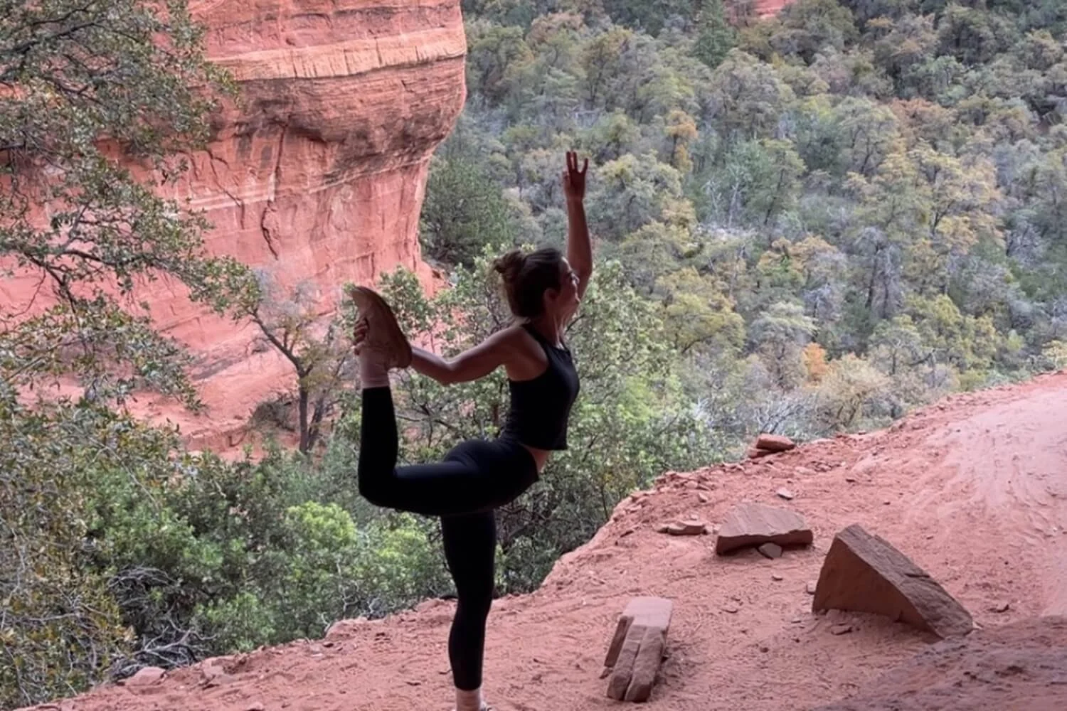 Jessica Taddeo practicing yoga while traveling in a red-rock canyon landscape.