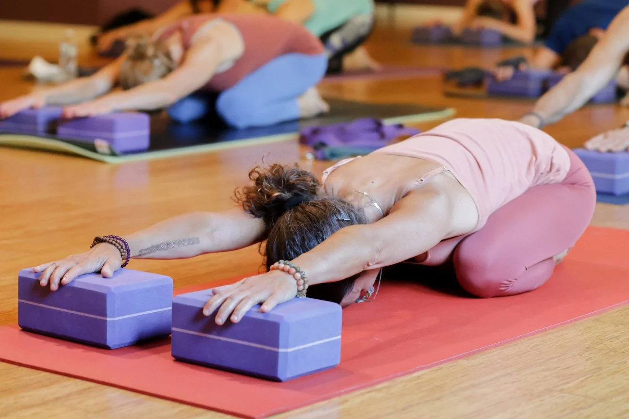 Supported child’s pose using yoga blocks to promote relaxation and nervous system regulation at Prana Yoga Center in Geneva IL