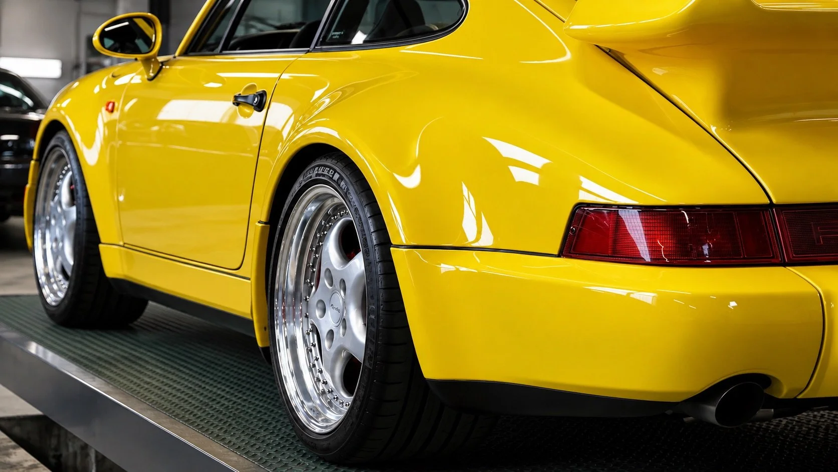 Glänzender gelber Porsche 911 in der Garage.jpeg