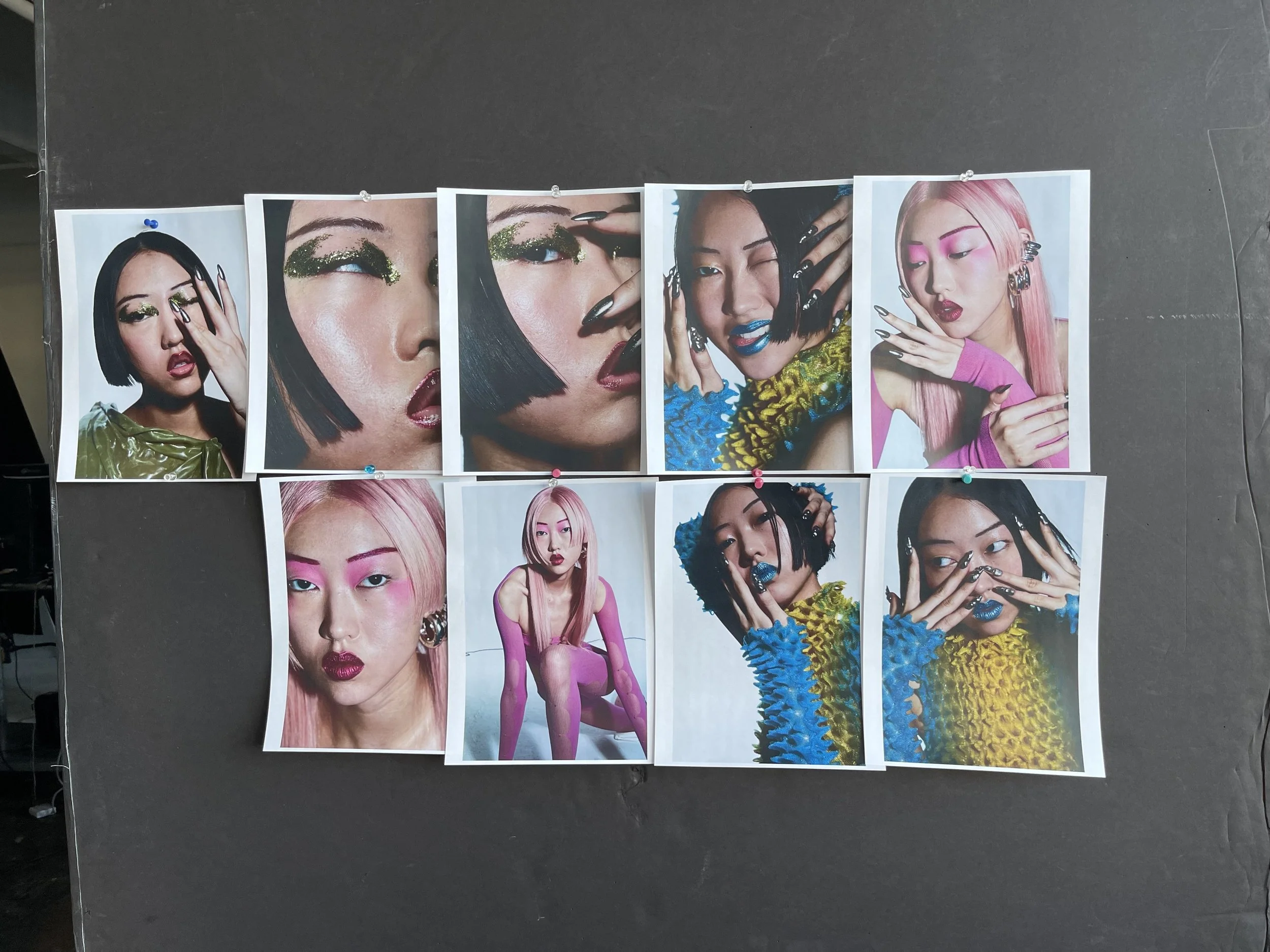 A collage of ten fashion photos of a woman with bright makeup and colorful outfits, pinned on a black background.