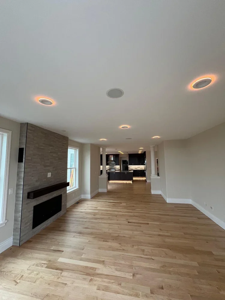 Open hallway with new hardwood floors, recessed lighting and modern fireplace