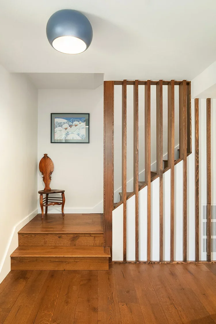 Staircase with custom wood slat railing and hardwood treads