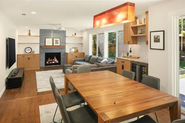 Open dining and living area with fireplace and custom wood built-ins