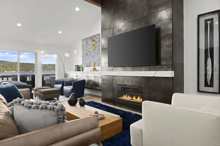 Living room with large tile fireplace wall, linear gas fireplace and lake view