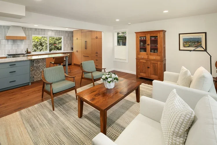 Living room open to the kitchen with wood floors and natural light
