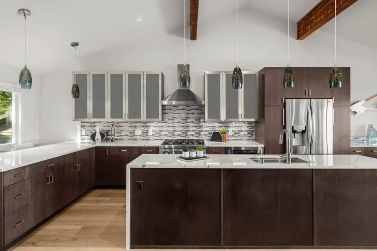 Dark wood kitchen island with quartz top, stainless hood and exposed beam