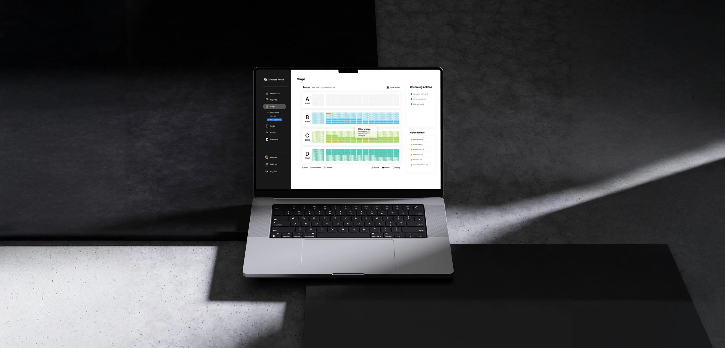 Laptop on a desk displaying a dashboard for crop management with different zones and upcoming actions.