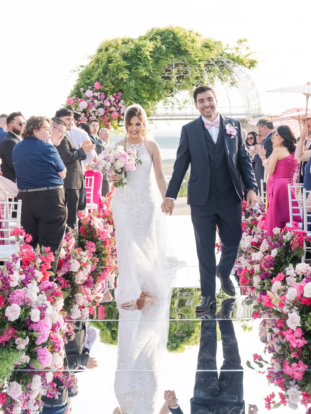 Newlyweds walking down the aisle as their guests applaud