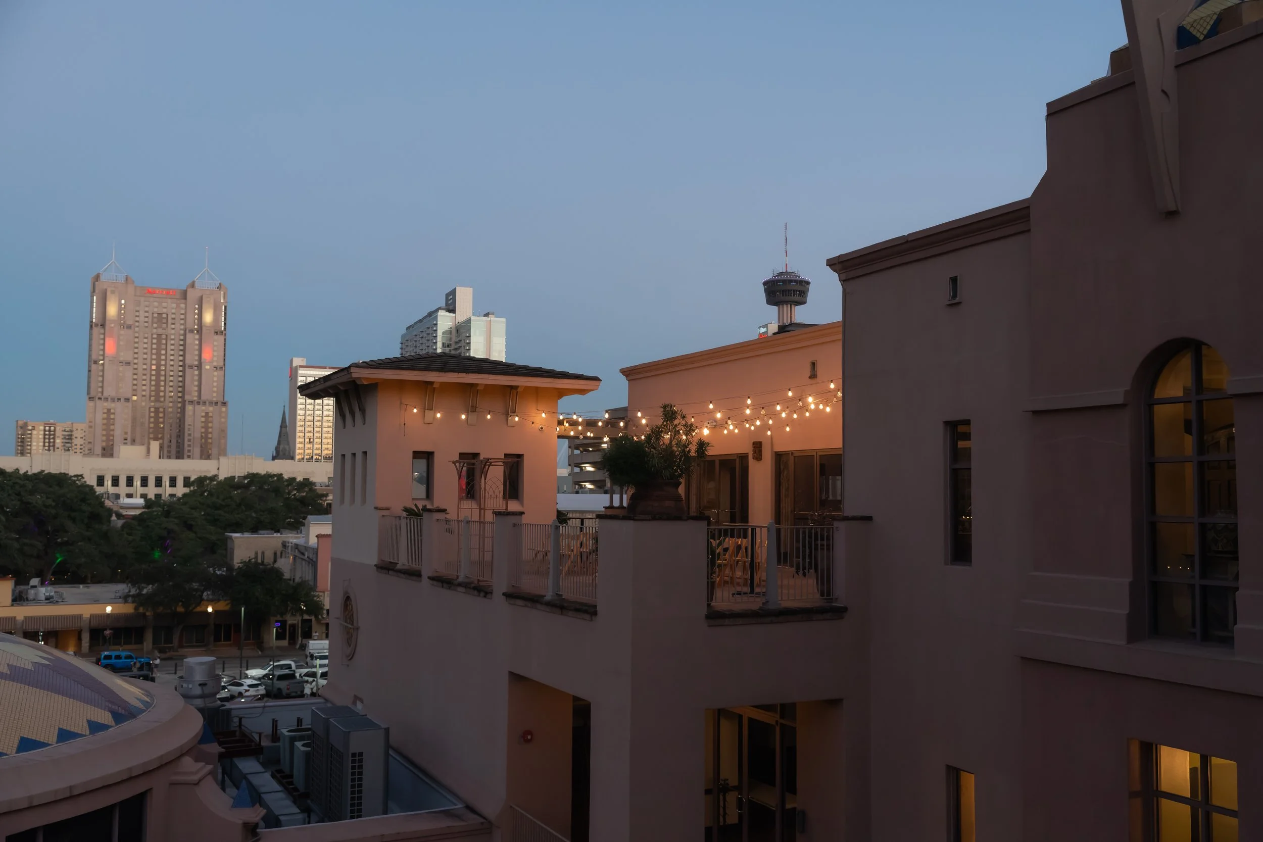 City buildings and a rooftop terrace at twilight.