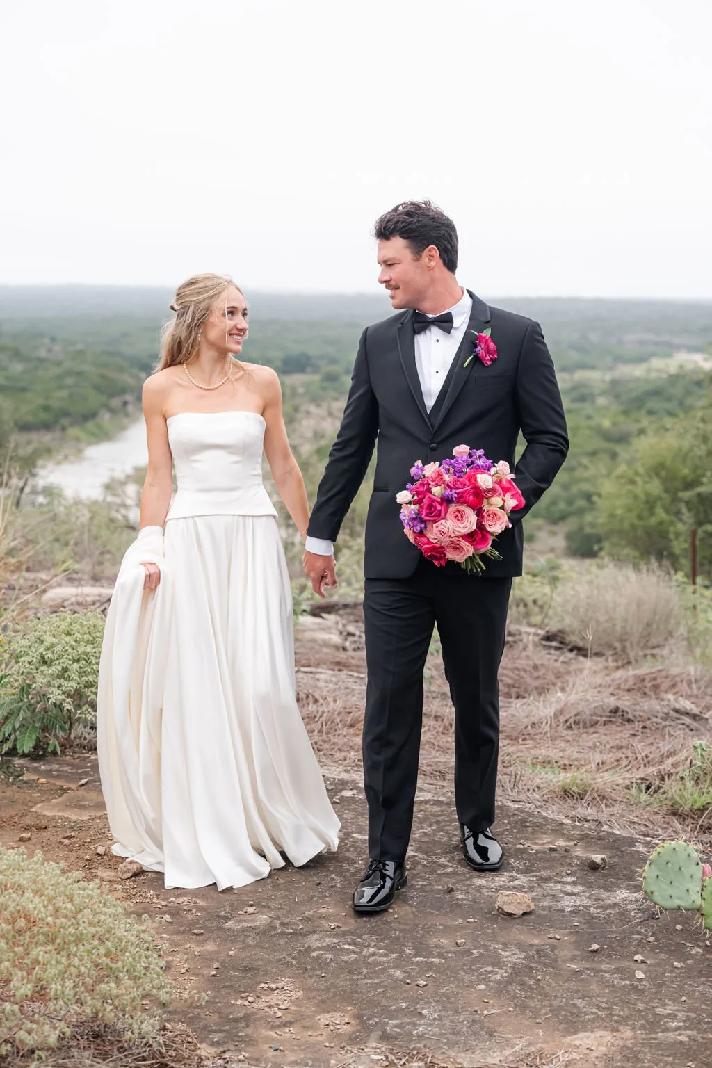 Lily and Steve walking hand in hand during their wedding portraits