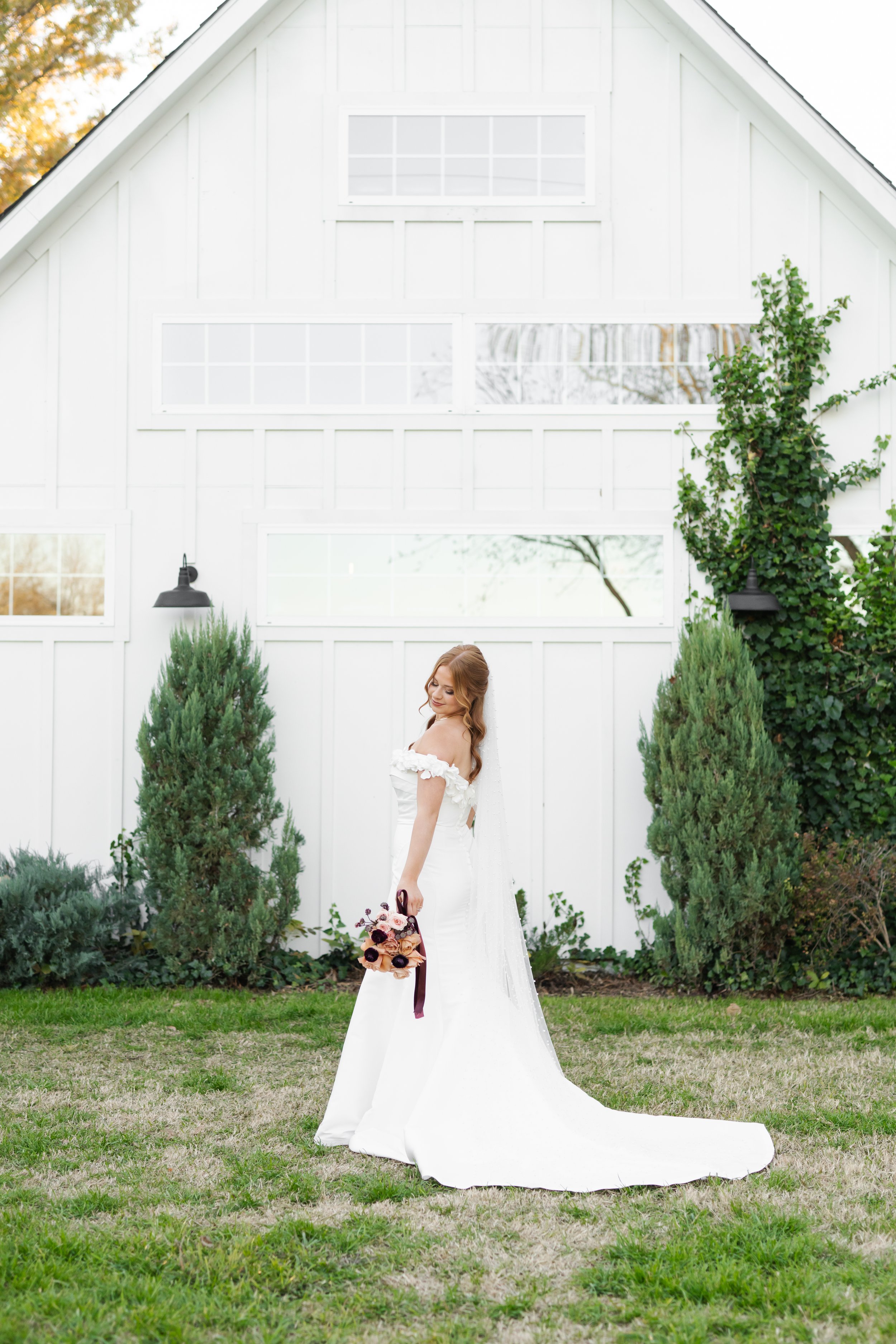 Bride standing eloquently holding her bouquet staring over her shoulder during her portrait session at The Rosemary wedding venue