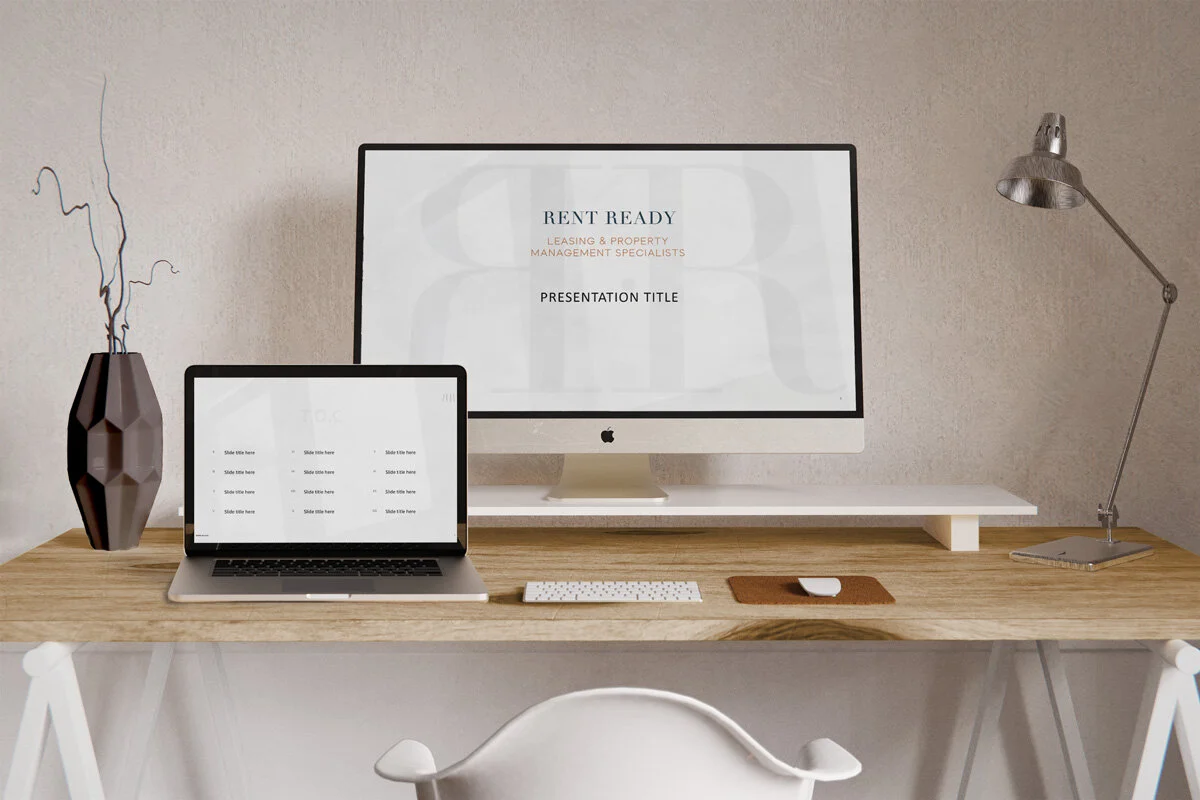 Image of iMac and Macbook on a desk, showing a mockup of a powerpoint deck.