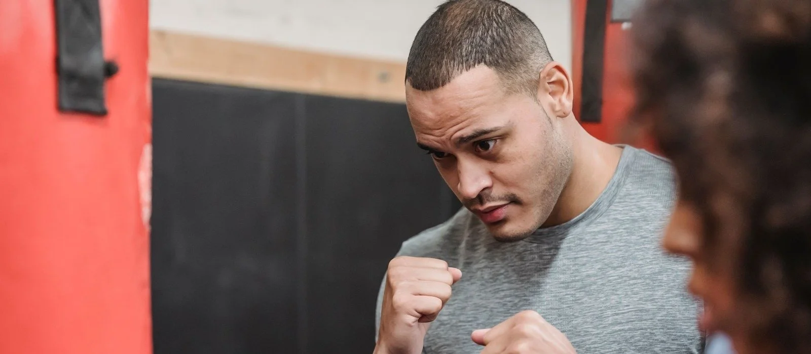 Coach teaching punch technique at a boxing gym