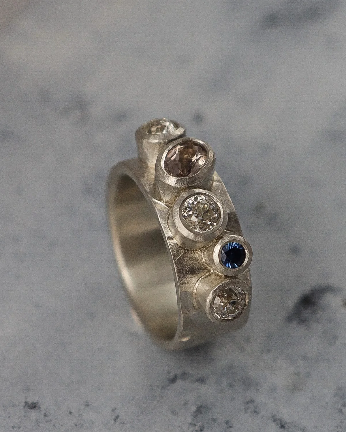 Diamond ring remodelling. 
Beautiful antique cut diamonds from an heirloom ring. My customer wanted the gemstones to be informally set on a wide Strata textured band in white gold. 
I carved every setting and the ring band by hand in wax before casti