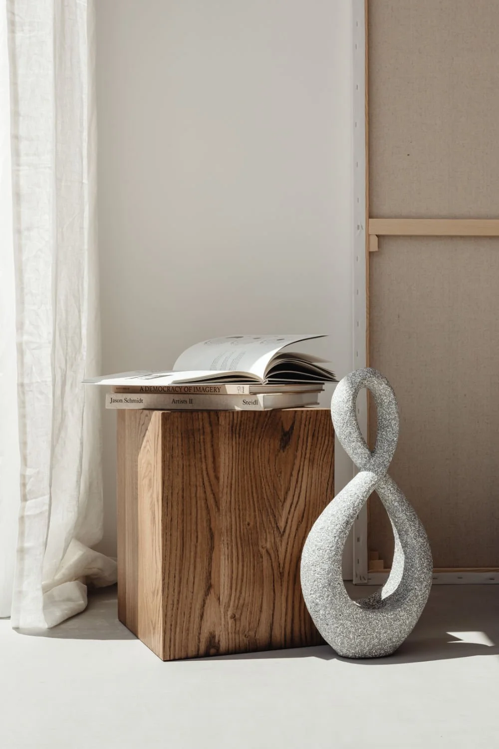 open book on side table wood cube with infinity sculpture