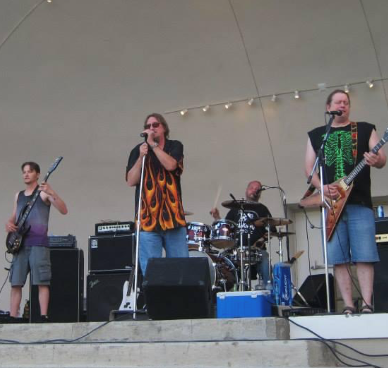 Kevin Michael Leis singing on stage with two other musicians