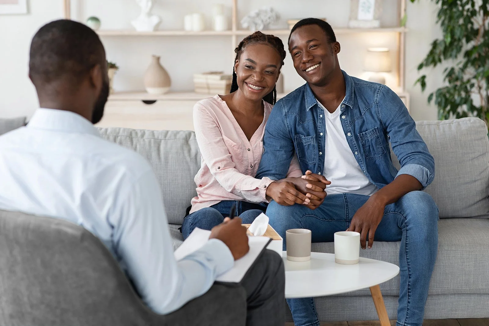 A picture of a couple sitting on a couch talking to a counselor