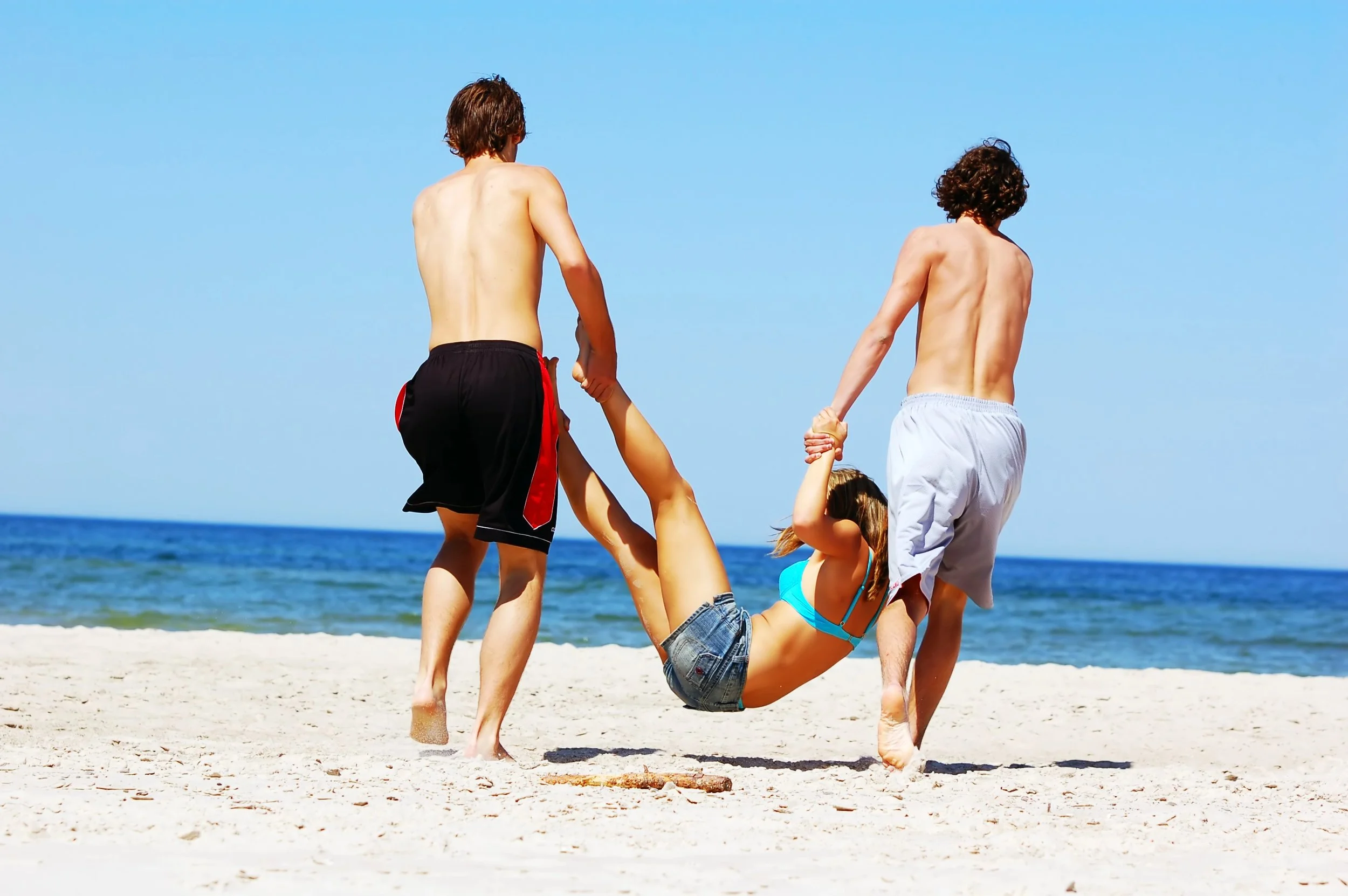 Photo of some teenagers having fun on the beach on a sunny day
