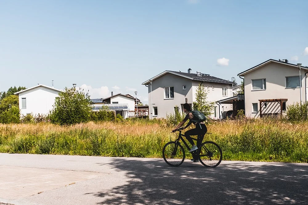 Valokuvia Muotialasta. Pyöräilijä alamäessä