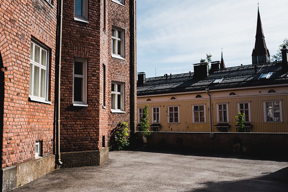 Valokuvia Juhannuskylästä. Kaunis sisäpiha, puutalo ja Tuomiokirkon torni