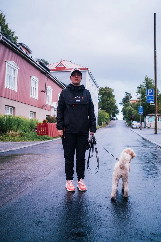 Nainen ja Koira Pispalassa. Koira kuuntelee toisen koiran haukkumista