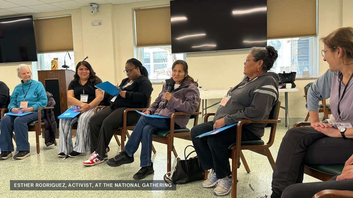 Esther Rodriguez speaking into a microphone while seated in a circle with other participants at the National Gathering