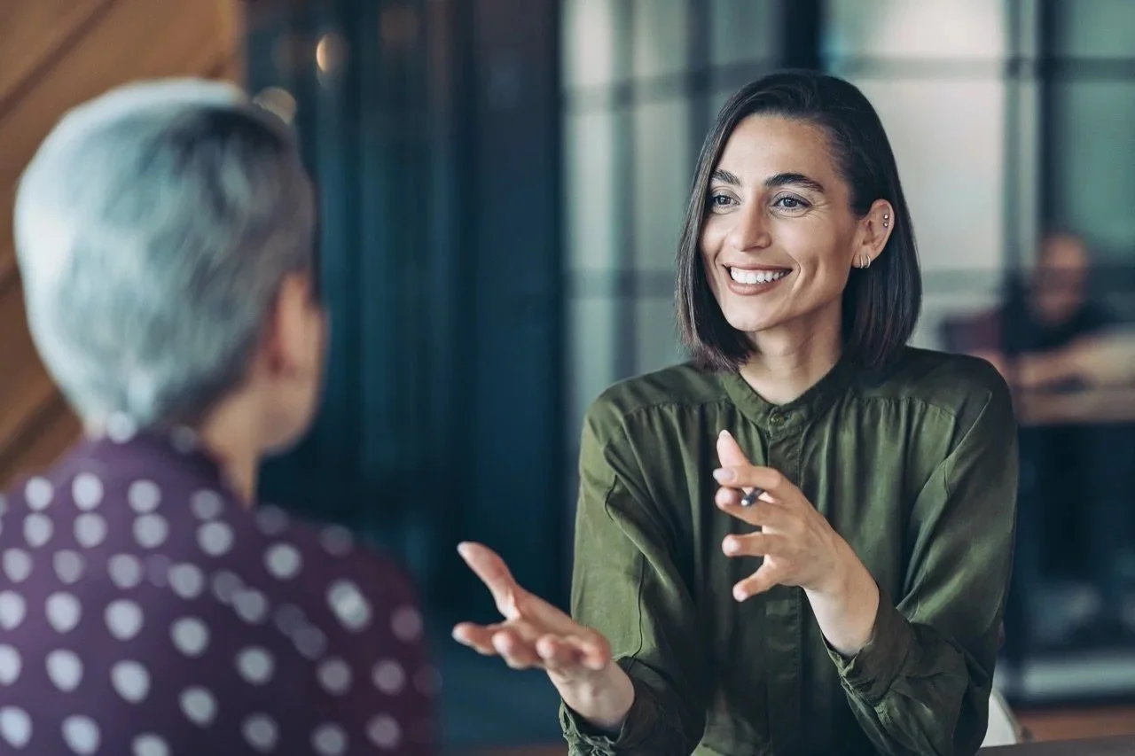 Deux professionnelles échangeant de manière positive lors d'une séance d'accompagnement et de coaching de gestion.