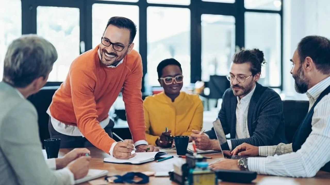 Gestionnaire en réunion d'équipe discutant de leadership et de prévention des risques psychosociaux (RPS).