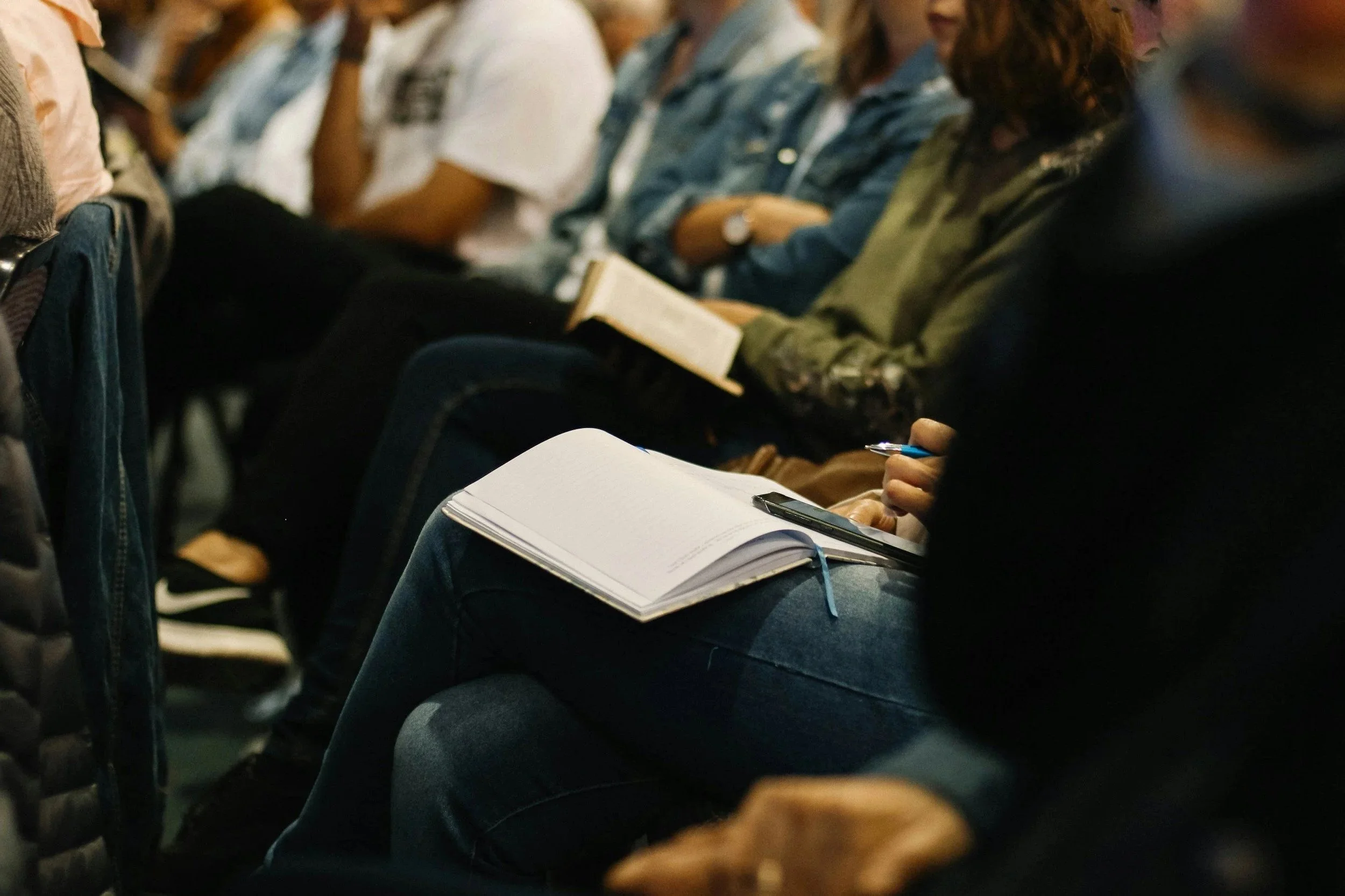Participants prenant des notes lors d’une conférence en entreprise.