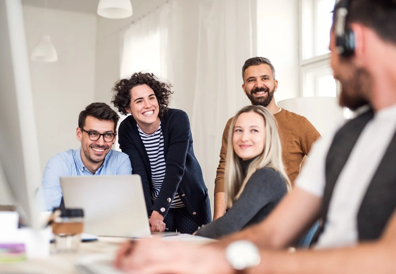 Équipe de travail échangeant lors d’une rencontre autour d’un ordinateur.