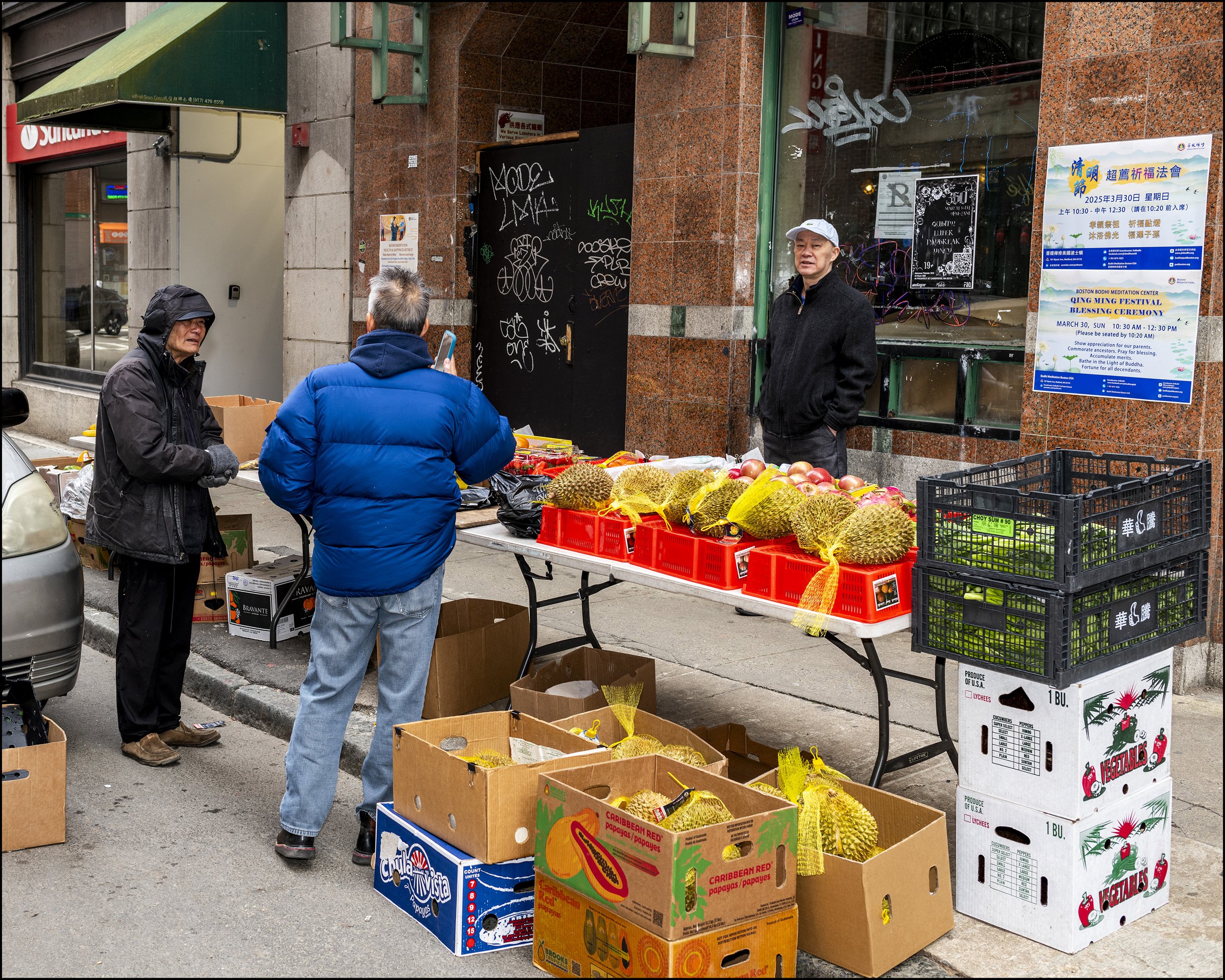 Jackfruit salesmen gather on the curb.