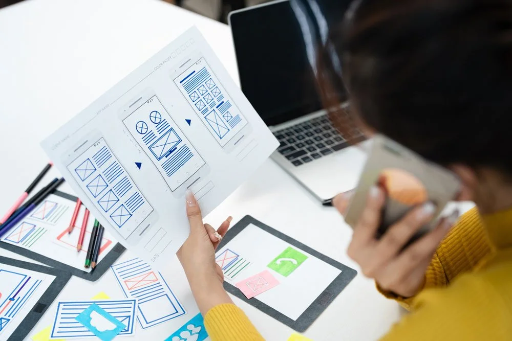 Redesign squarespace website: Desk covered with wireframe and redsign ideas
