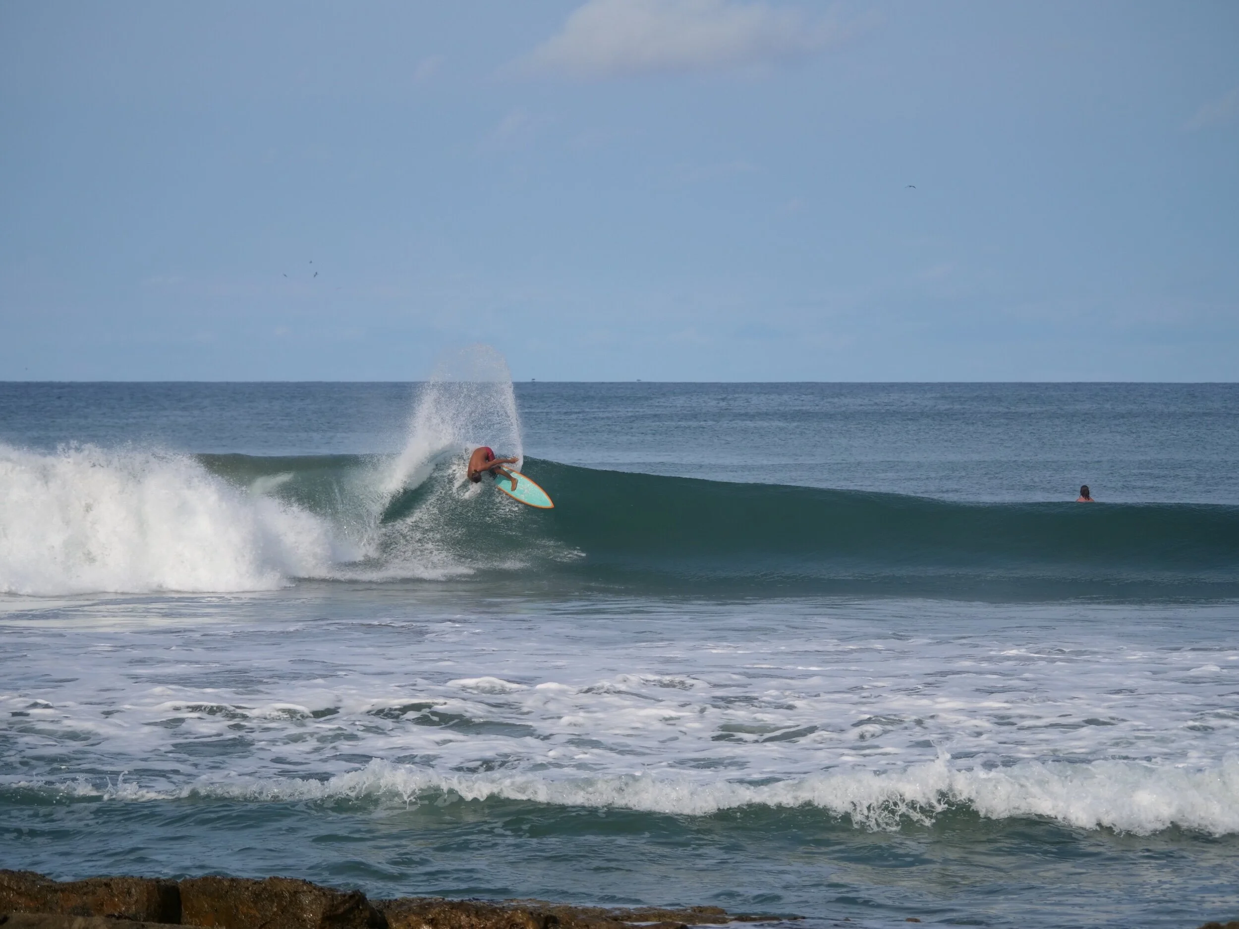 Surfer catching wave at Playa Yankee Nicaragua 