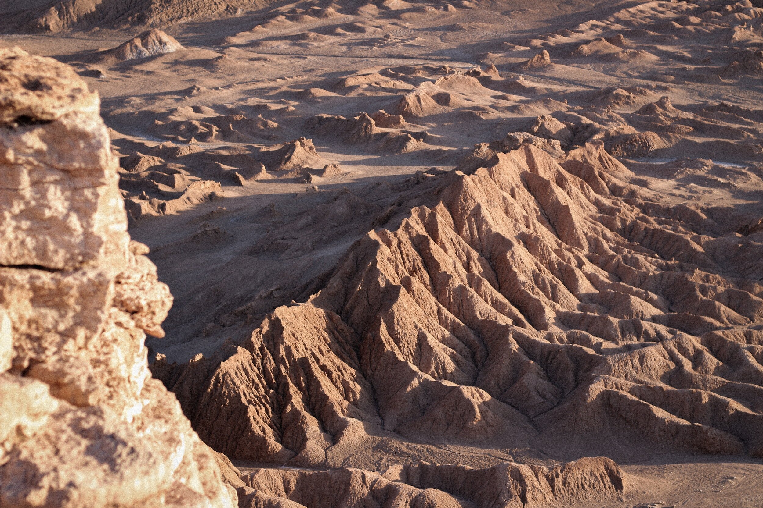 A ridge line surrounded by rocky outcrops in the desolate and Mars-like Valle de la Luna park in San Pedro de Atacama