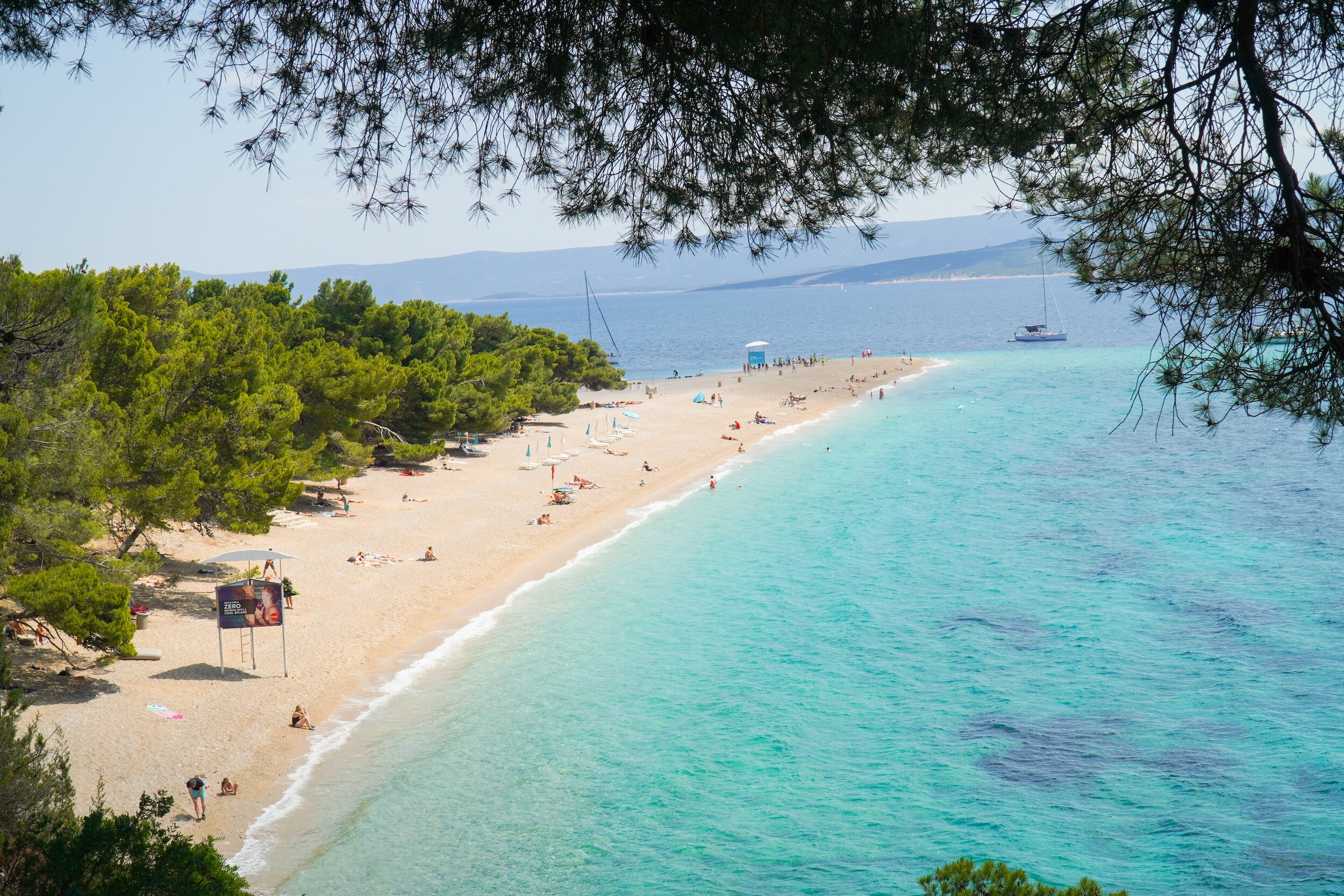 Golden Horn beach, backed on one side by bright green trees and on the other by clear turquoise sea on the Croatian island of Bol.
