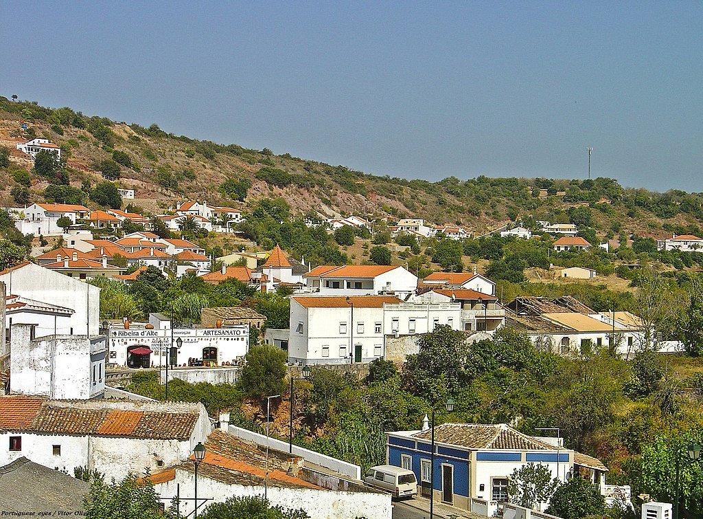 The small town of of Alte surrounded by hills covered in green and brown scrub in Portugal's Algarve region.