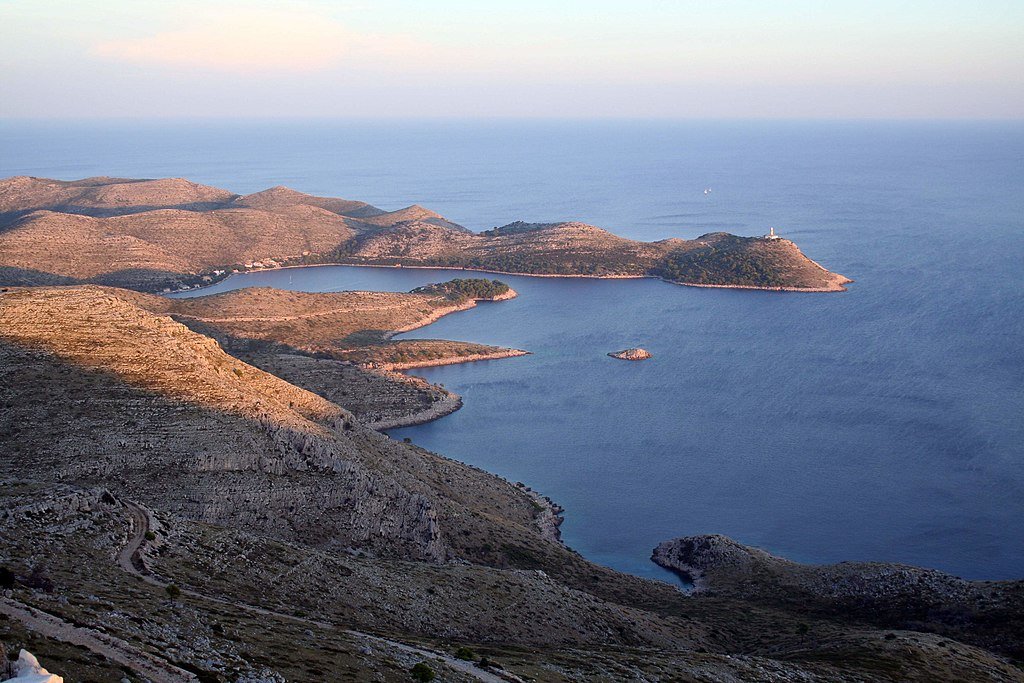 Rocky brown strips of land push out into the blue sea on Lastovo island in Croatia.