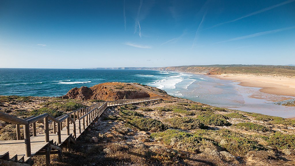 The long wooden walkway leading out to the empoty, wide sandy Praia da Bordeira beach, near Carrapateira, Portugal