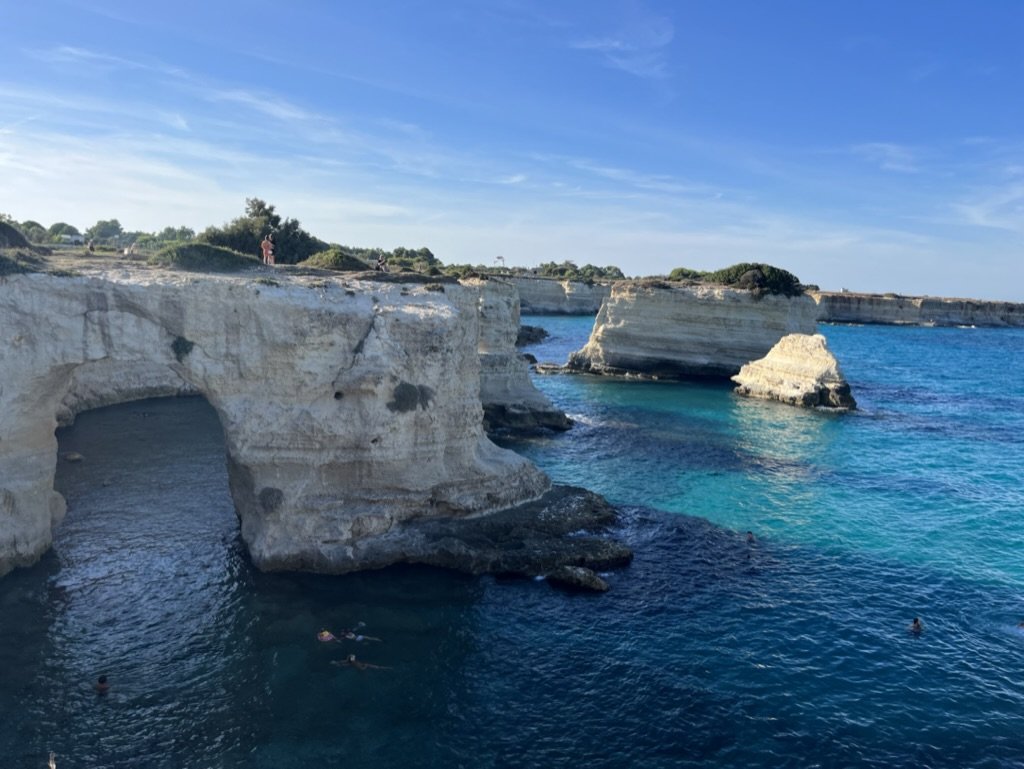 The famous limestone arch, surrounded by turquoise water and limestone cliffs, at Torre Sant'Andrea beach on the Salento coast north of Otranto, Puglia.