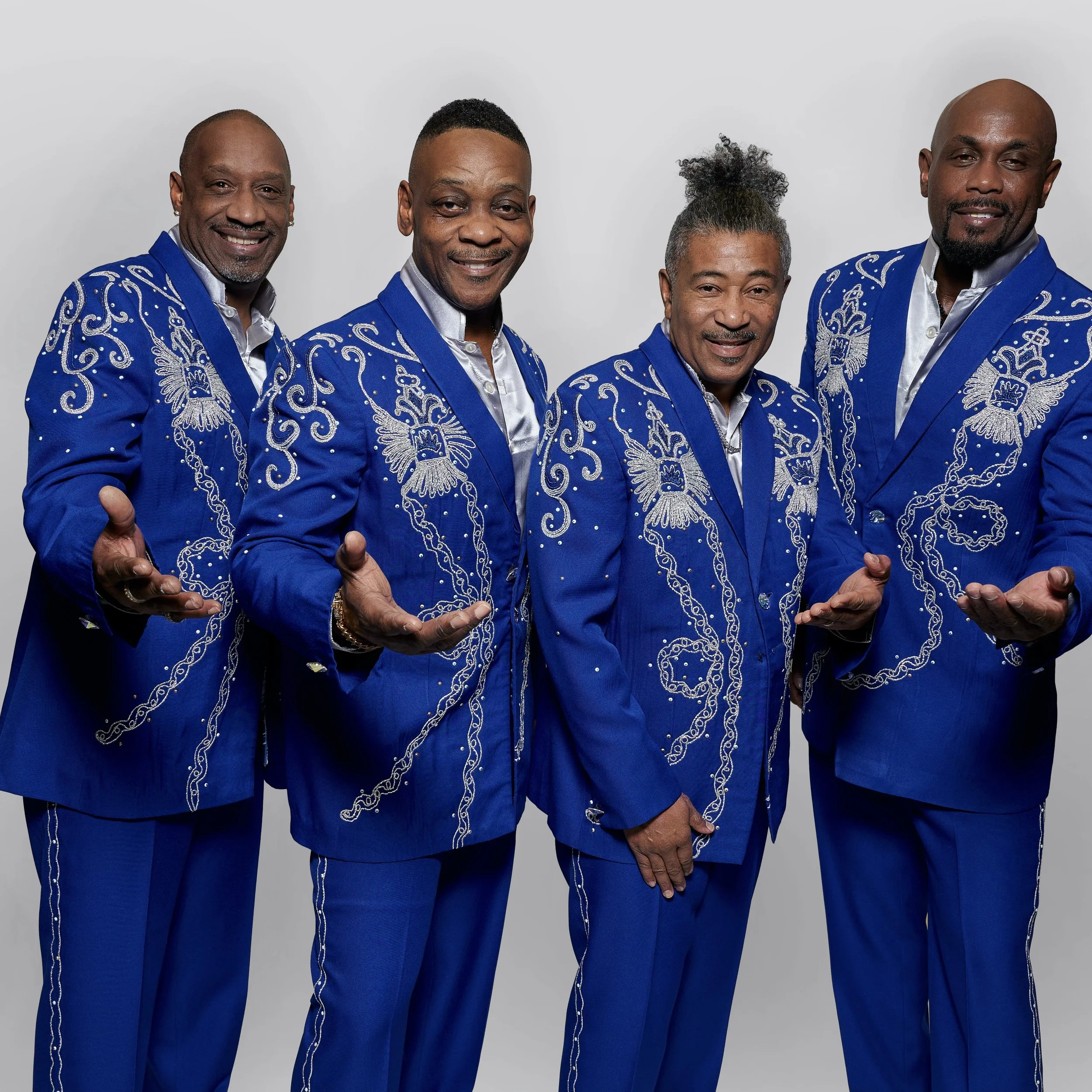 Poster for a performance by The Spinners on August 2nd at Cape May Convention Hall at 8 pm. The poster features a photo of the four male band members dressed in black shiny jackets with white shirts, standing against a gradient background. The logo for SpyBouw Productions is at the bottom right corner.