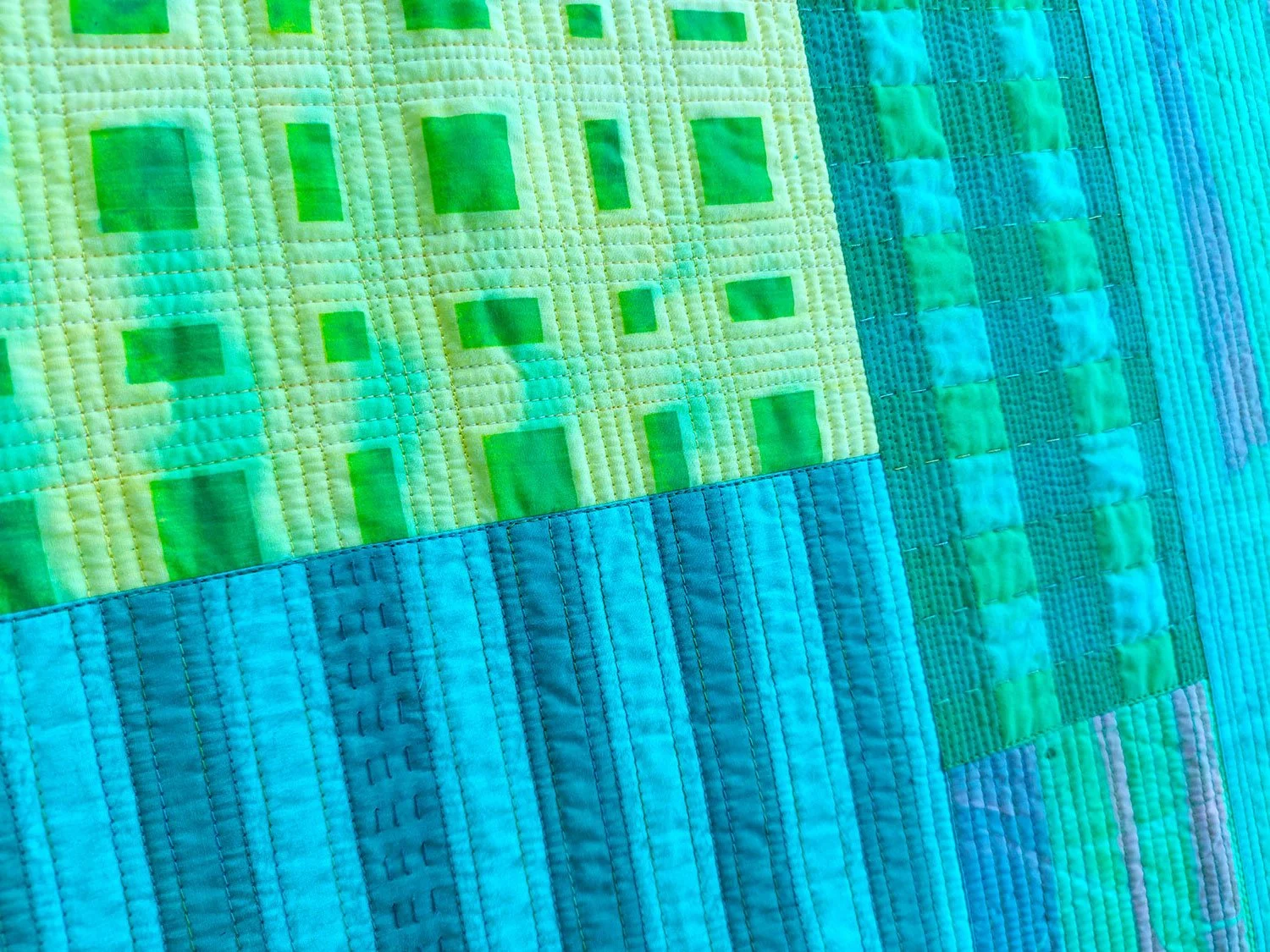 Machine stitching on a green grid quilt