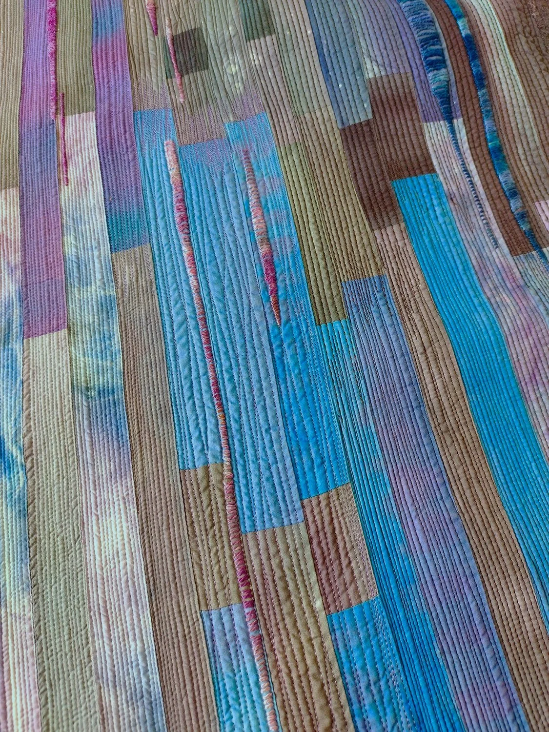 Detail of close stitching on abstract landscape quilt